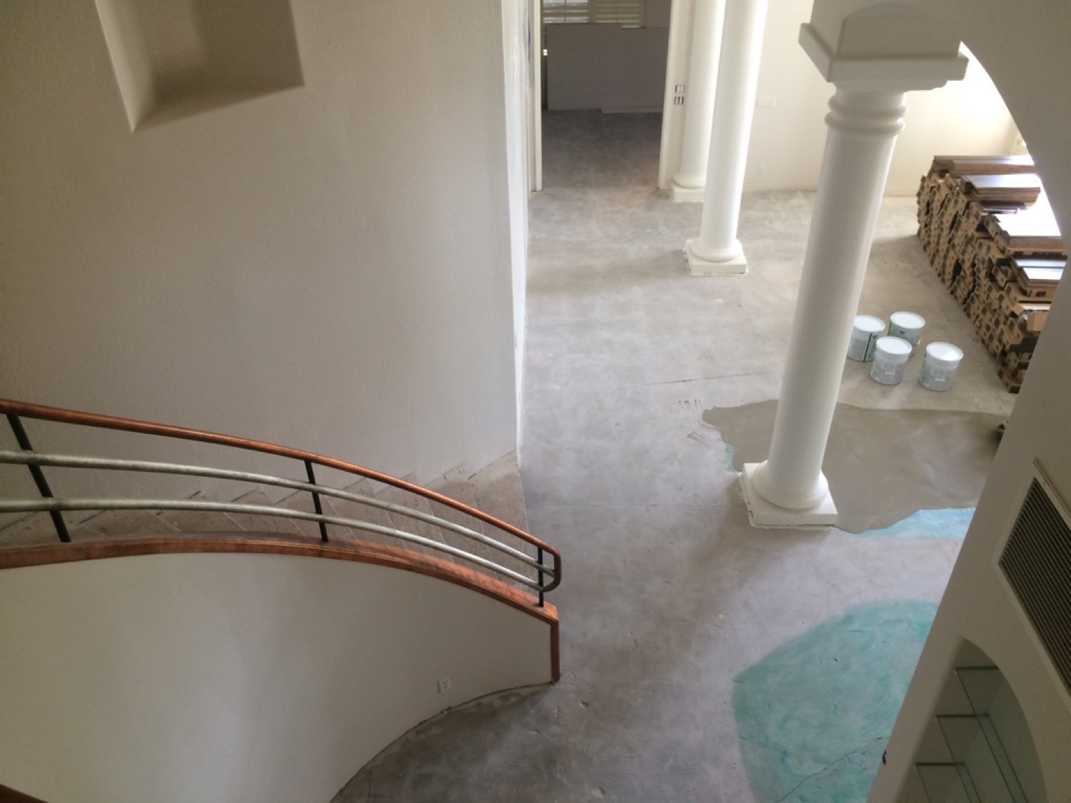 A curved open-sided staircase covered in worn carpet before the hardwood installation