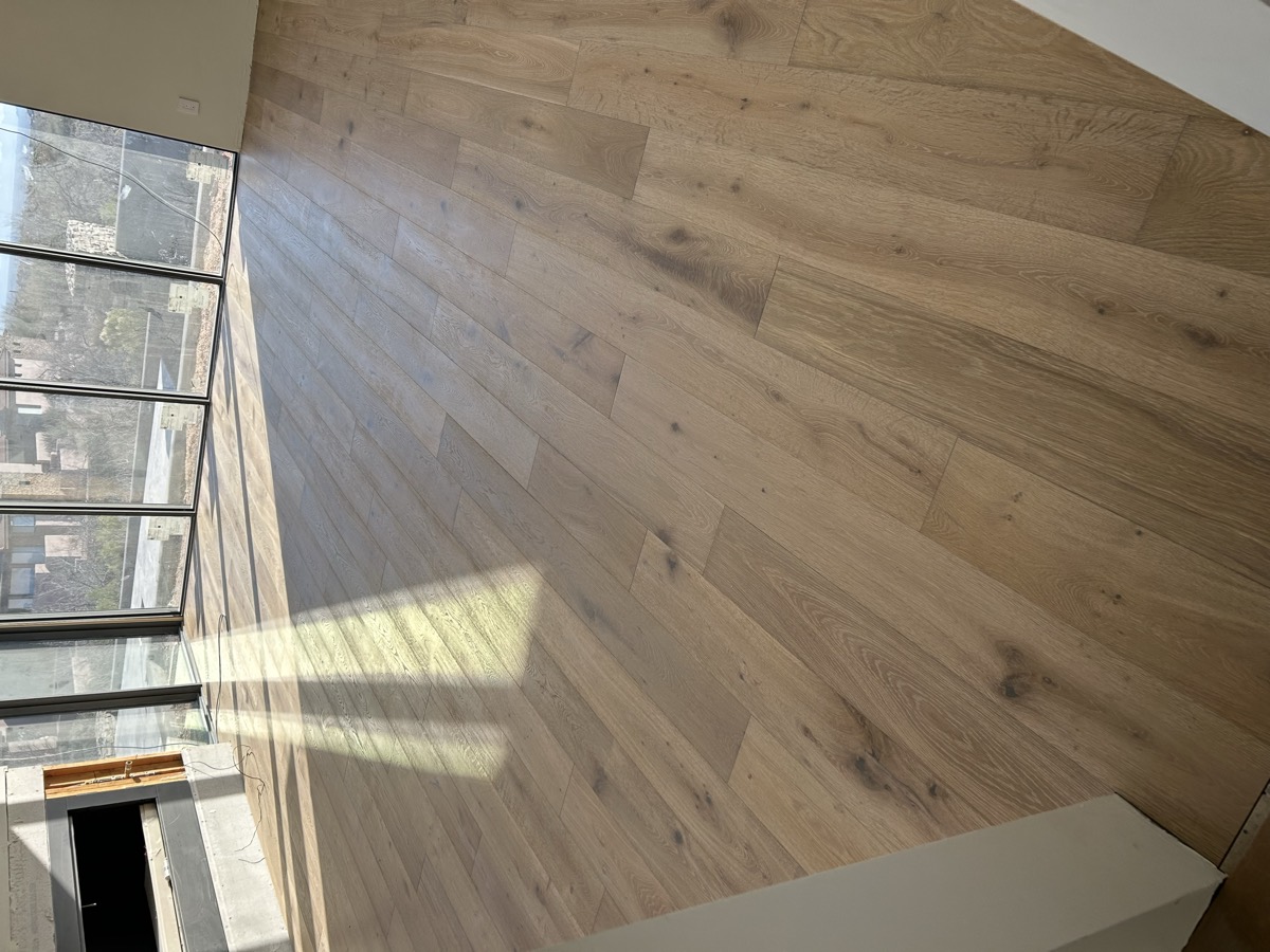 Sunlit room with glass walls and wide plank oak flooring