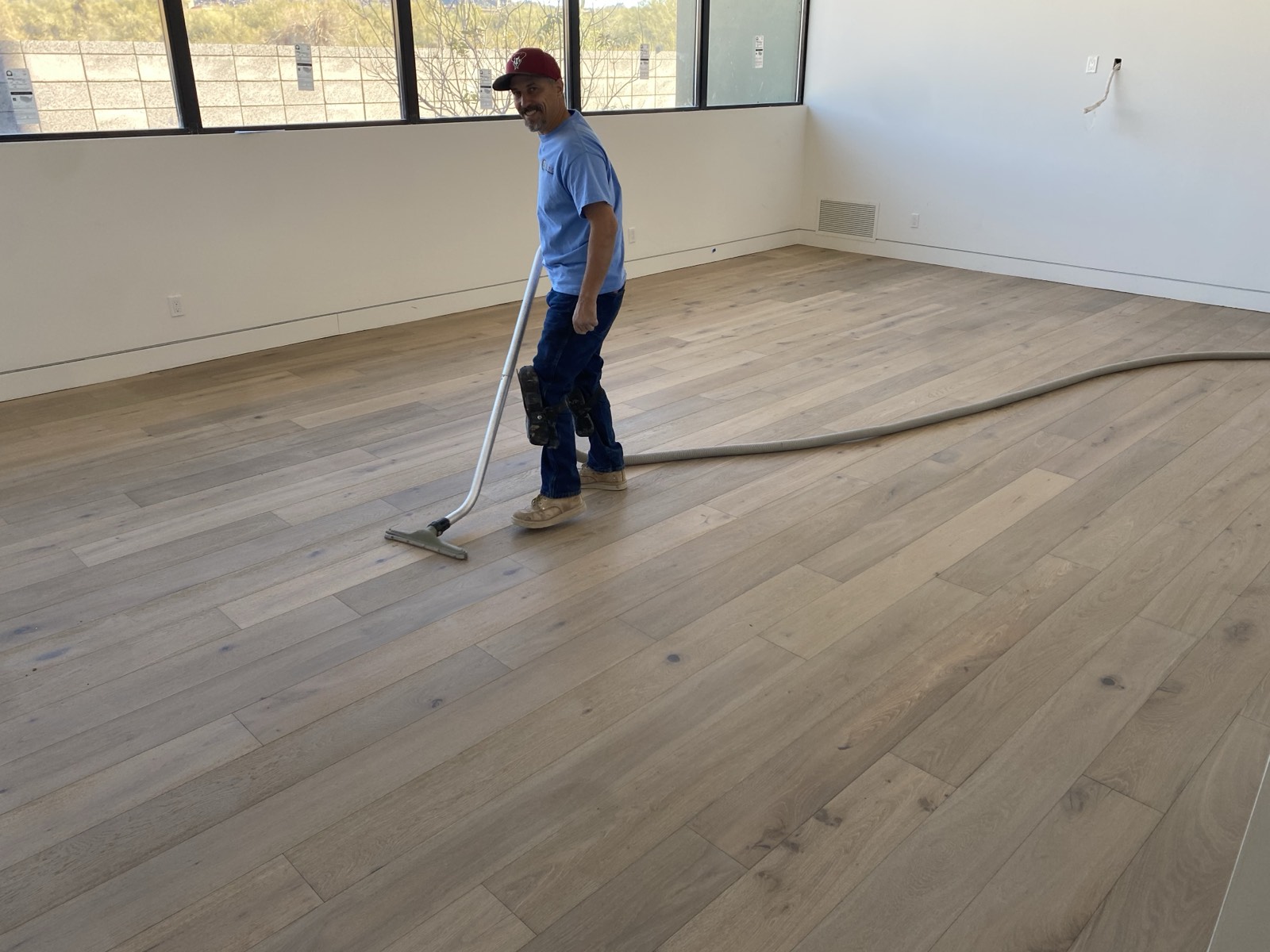 Vacuum hose running from a floor grinder during dustless tile removal