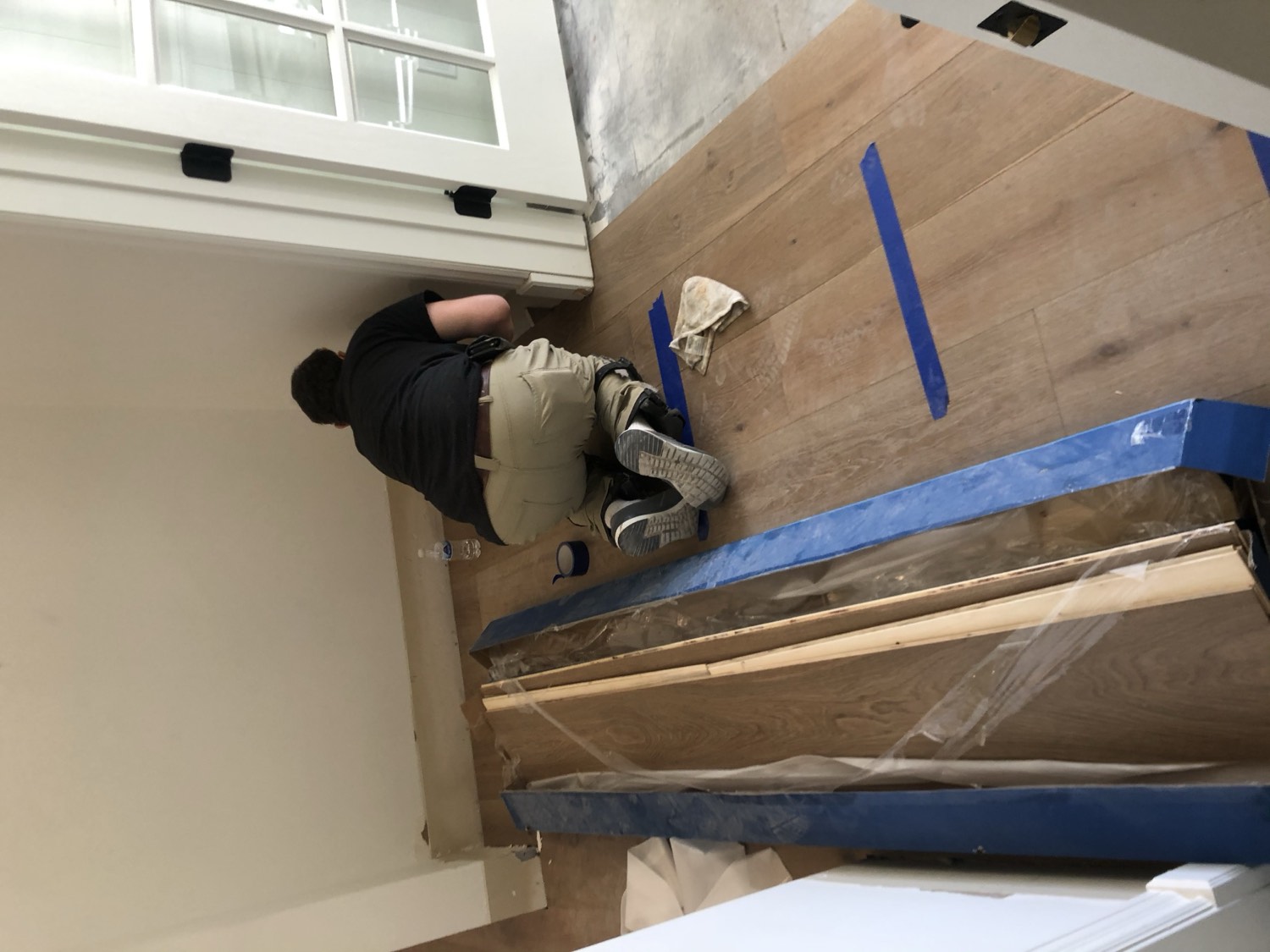 Olympic crew setting out a run of hardwood on a jobsite with expansion space held at the wall