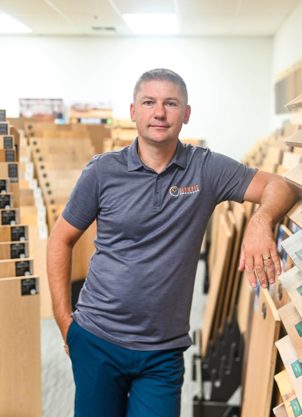 Rafal Nalej, owner of Olympic Hardwood Flooring, standing among the sample racks in his Phoenix showroom