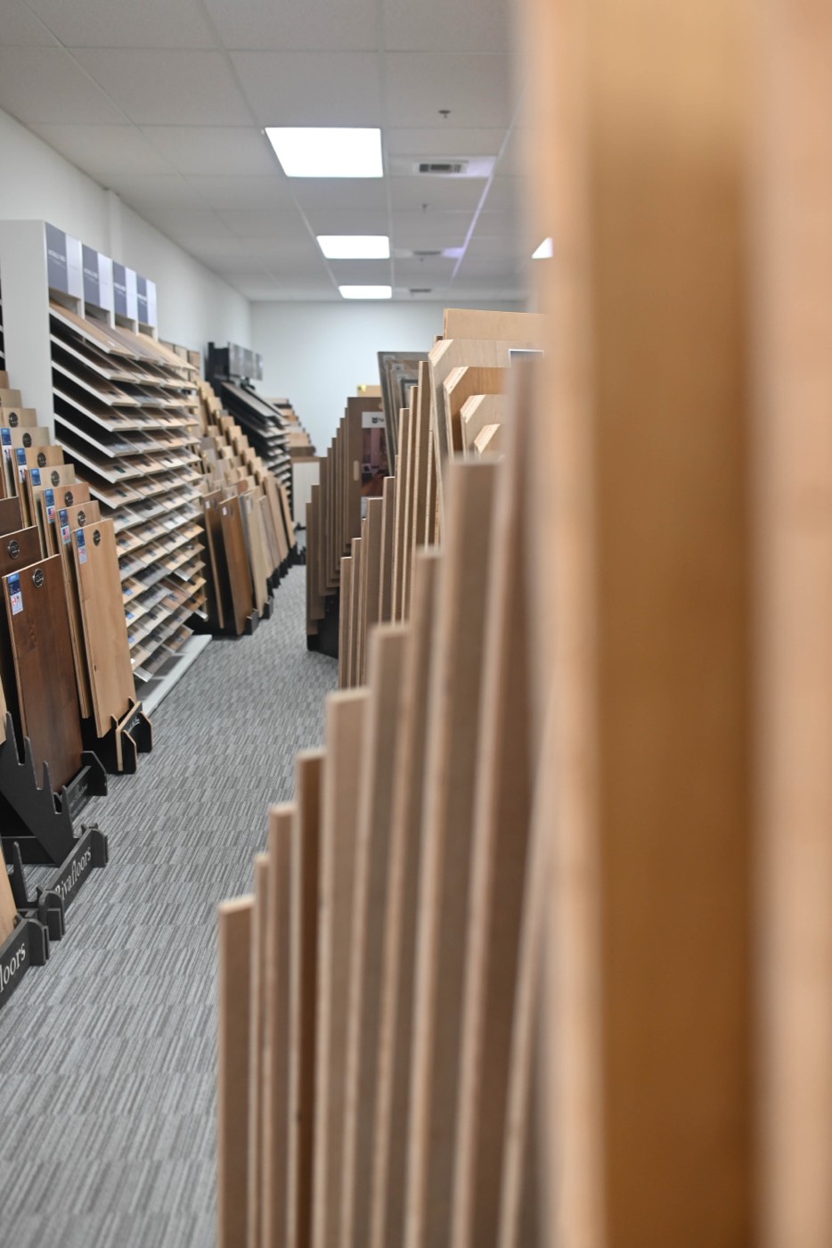 Tall racks of long wide plank boards in the aisle of the Phoenix flooring store