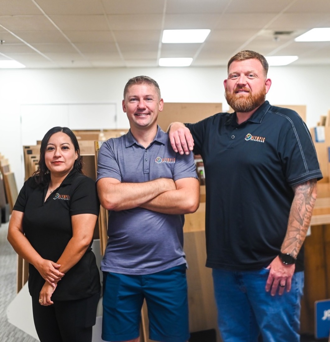 The three-person Olympic Hardwood Flooring team standing together in their Phoenix showroom