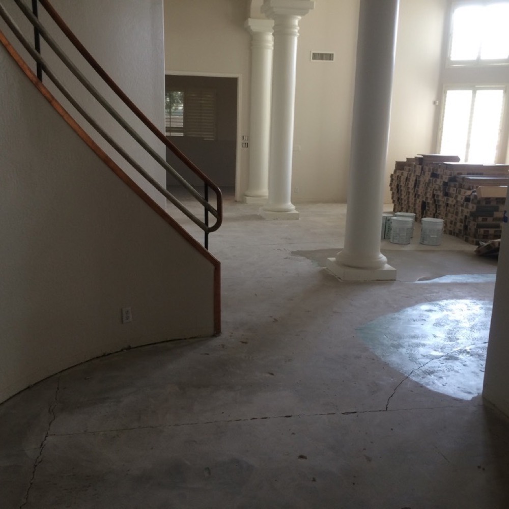 Great room with the old floor removed, bare concrete slab visible